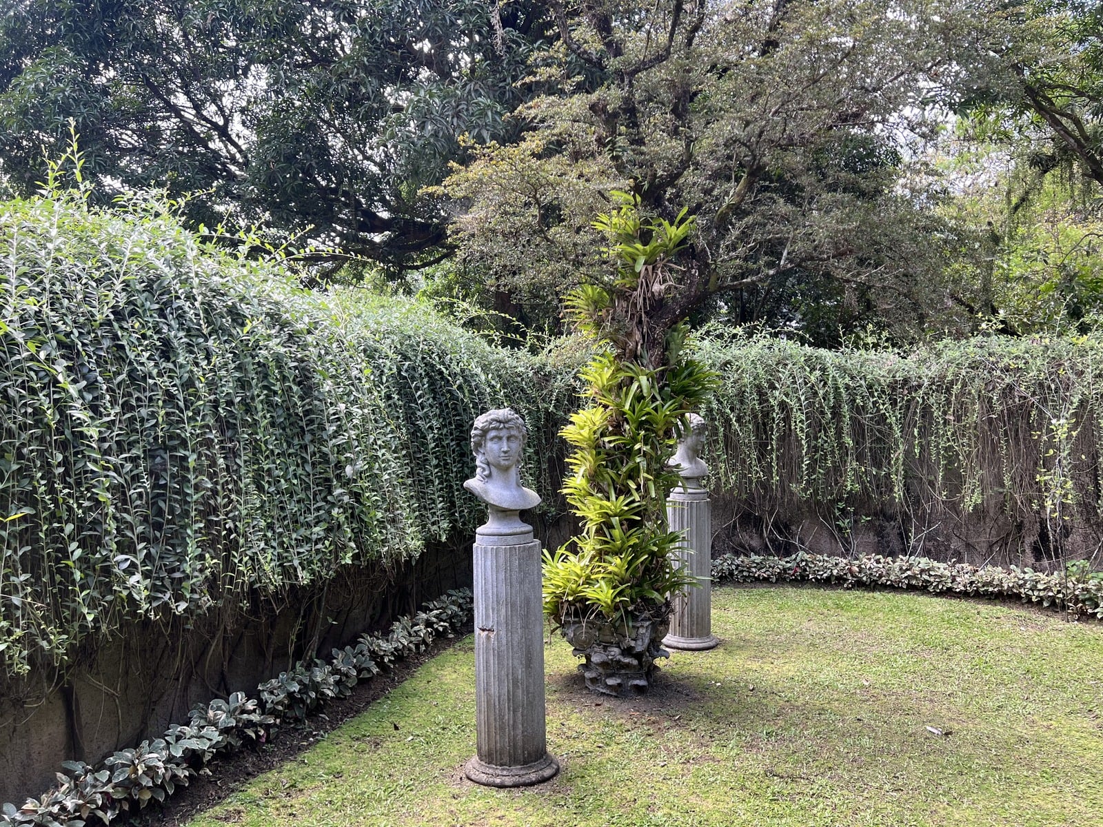 Landscaped garden with stone statues, editorial composition